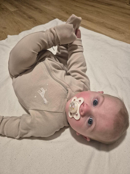 Bébé habillé en pyjama évolutif et zippé avec une girafe sur sa poitrine