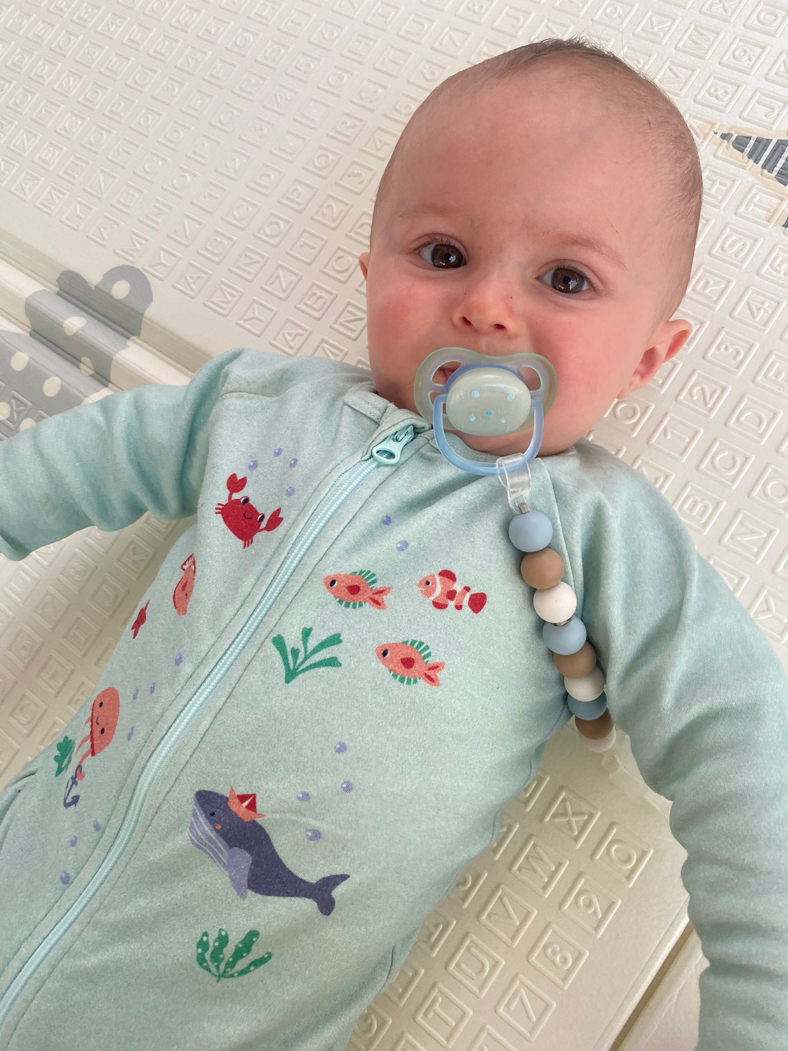 Bébé vêtu du pyjama "nager au mileu des coraux" de la collection mer.