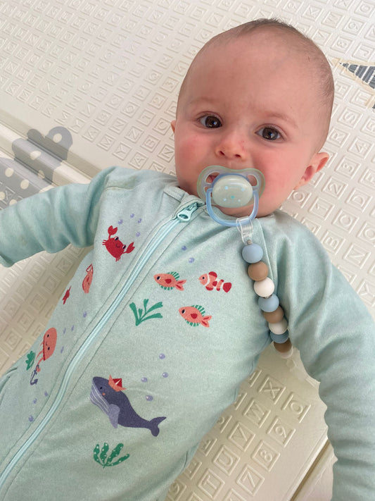Bébé vêtu du pyjama "nager au mileu des coraux" de la collection mer.
