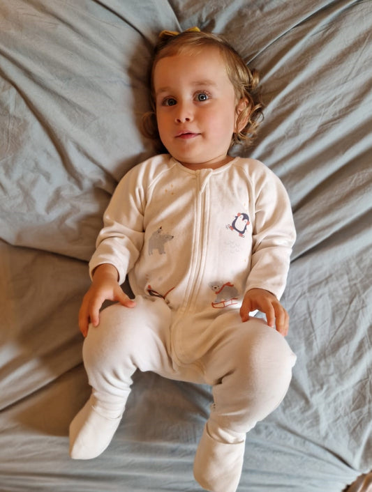 Bébé allongé sur le lit portant le pyjama motif polaire
