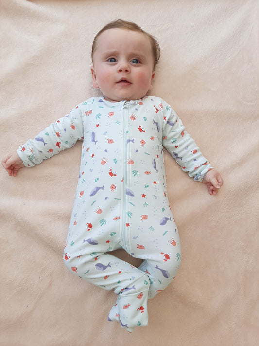 Bébé allongé vêtu de son pyjama de la collection mer.