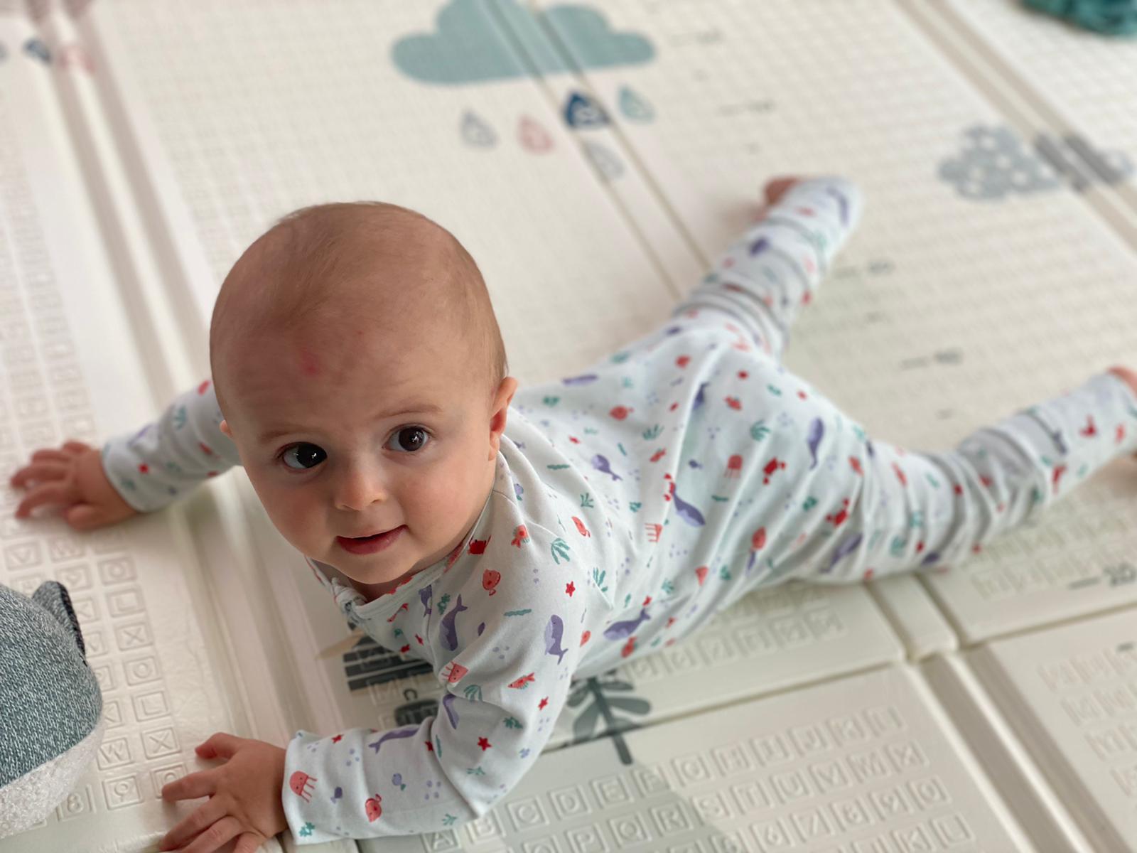 Bébé habillé avec son pyjama de la collection mer se baladant sur son tapis de jeu. Bébé à l'aise et confortable dans son pyjama.