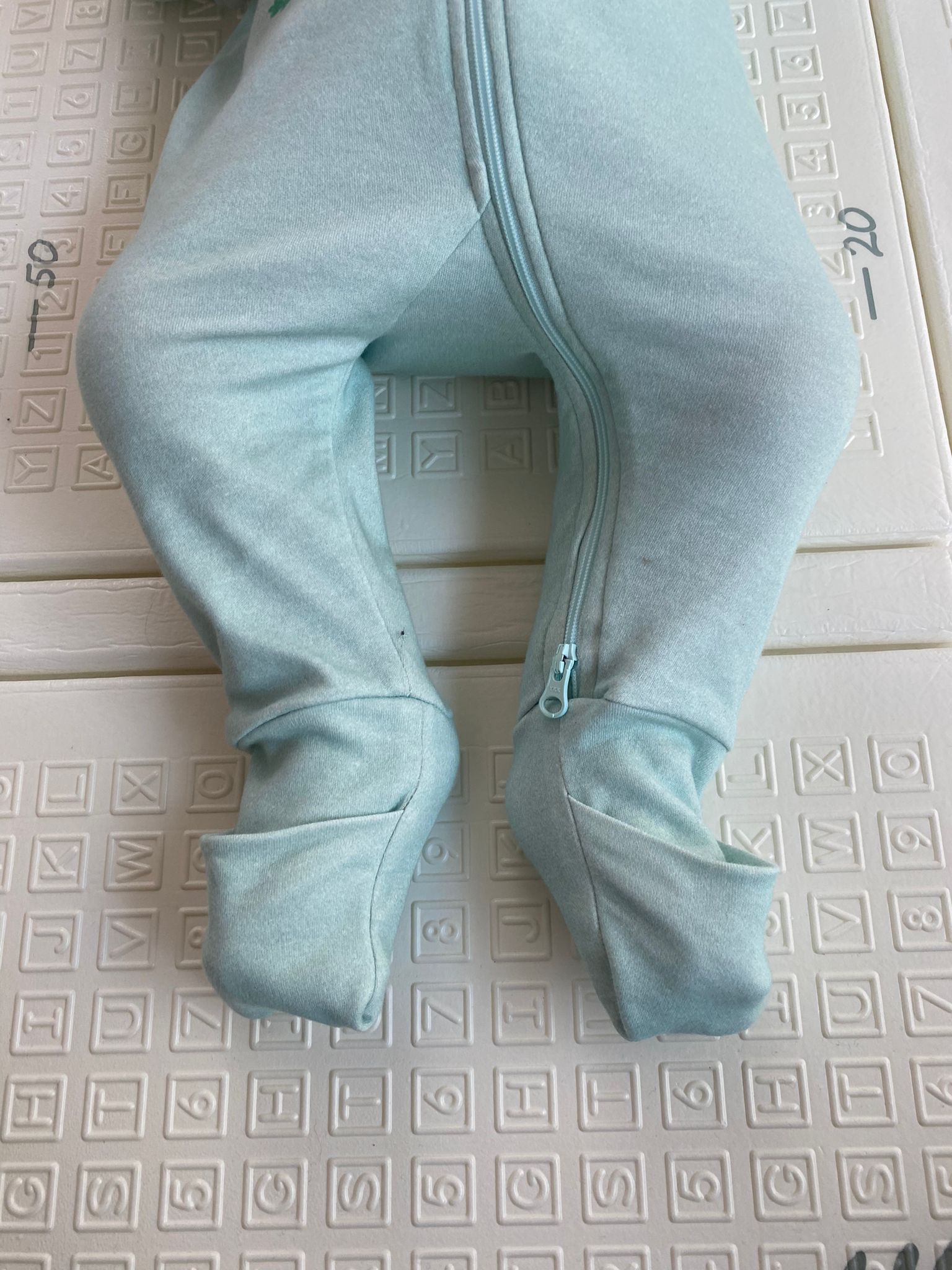 Focus sur les pieds de bébé portant le pyjama avec les chaussettes fermées.